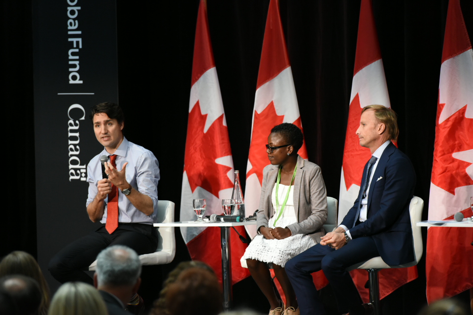 グローバルファンドへの誓約を話すカナダのトルドー首相。中央は、HIVと結核のサバイバーでグローバルファンドアドボカシーにあたるLoyce Maturu（ジンバブエ）。右はグローバルファンドのマーク・ダイブル事務局長